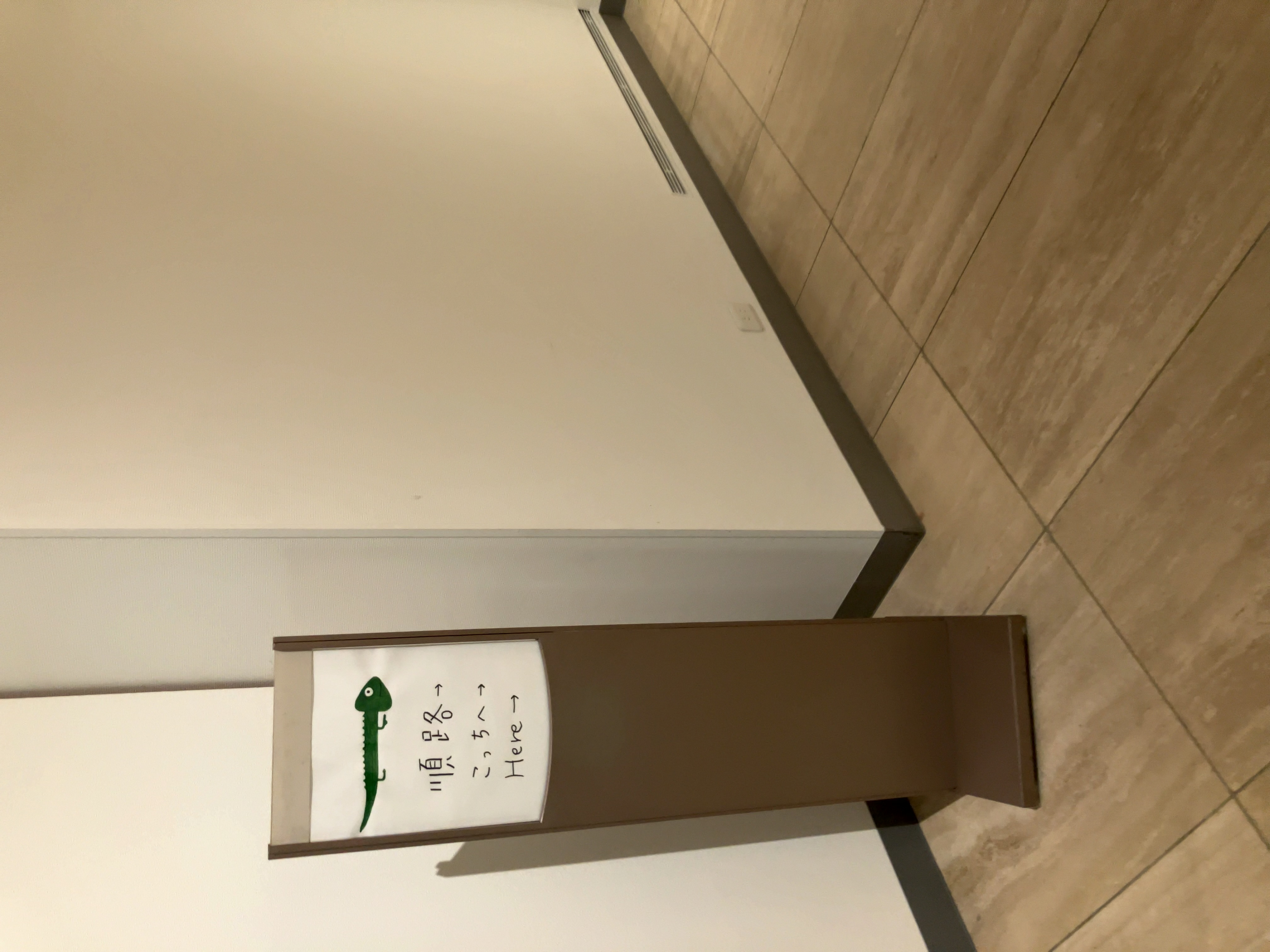 カメレオンのような生物が矢印になっている順路の看板