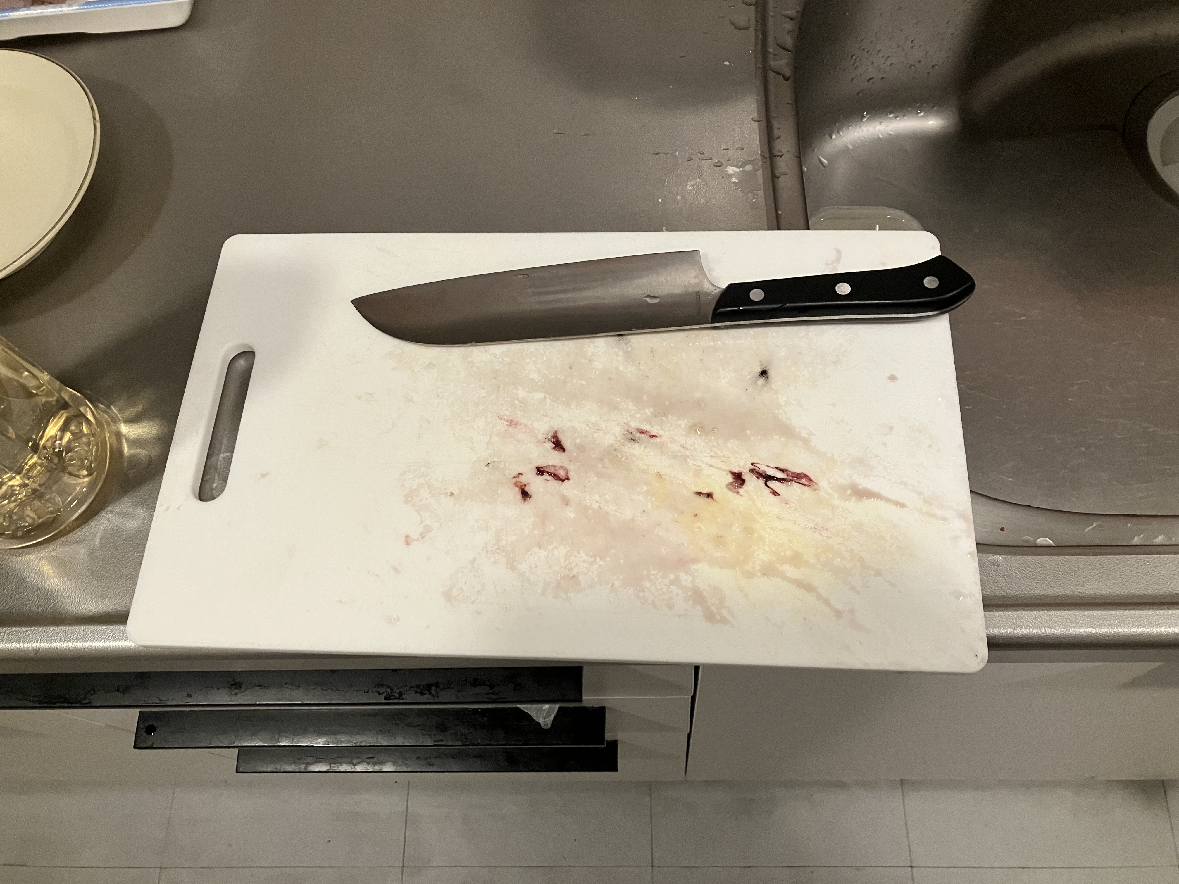 イカを色々したあとのあとが残ったまな板とその上に置かれている包丁