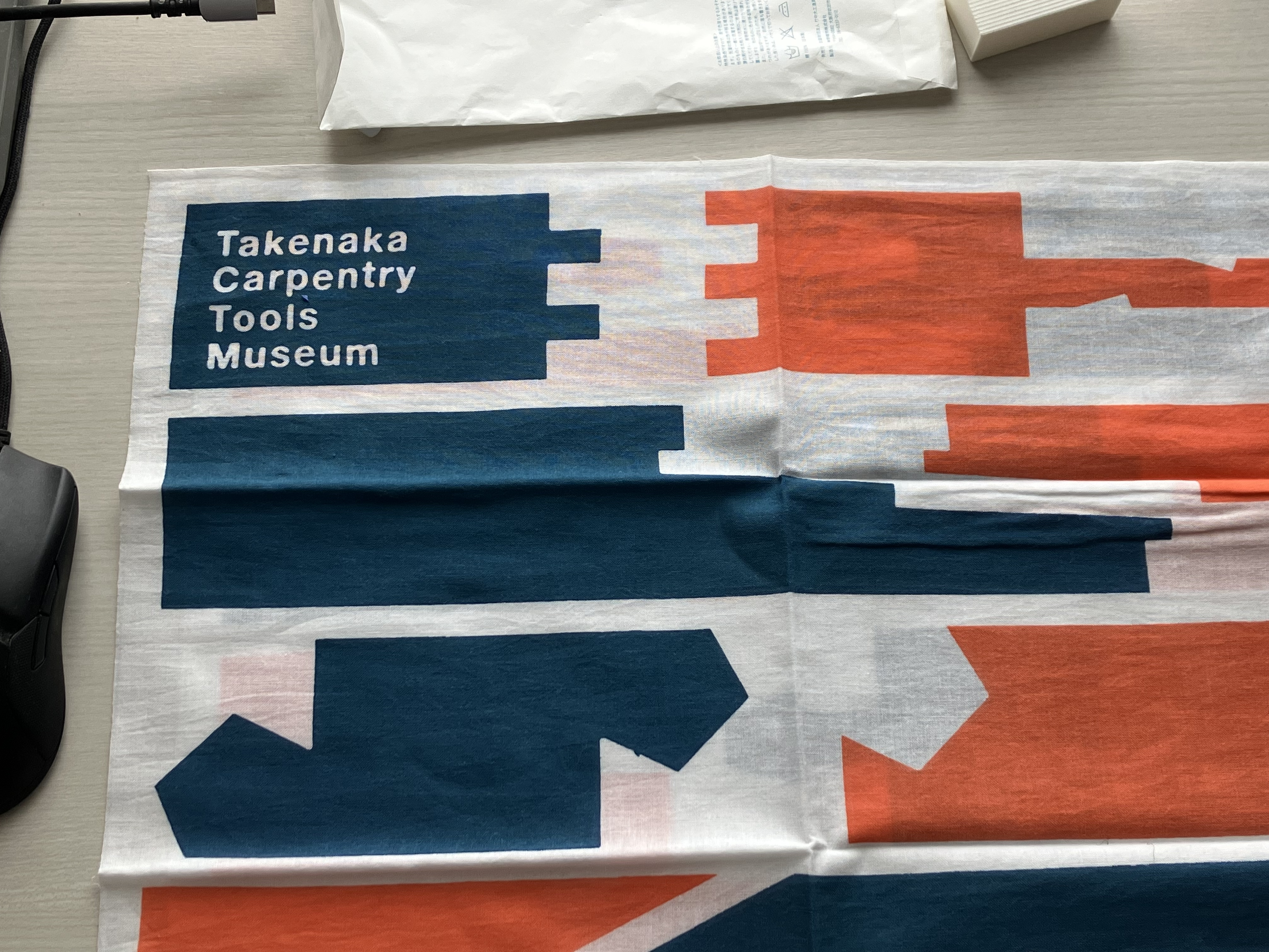 竹中大工道具館で買った手拭い。白い生地に藍と朱で色々な形に加工された継手があしらわれている