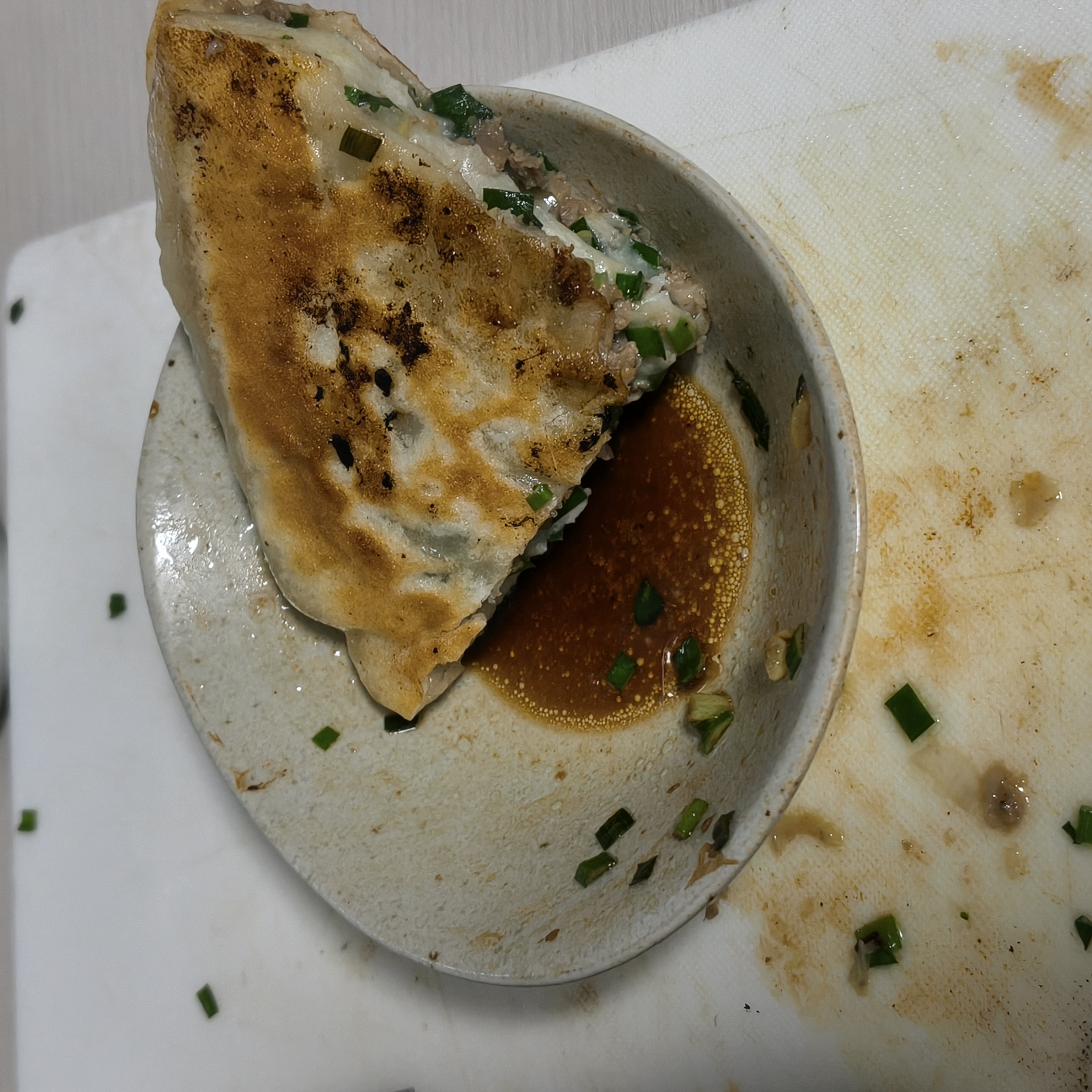 酢醤油を入れた小皿の上に一切れの肉餅